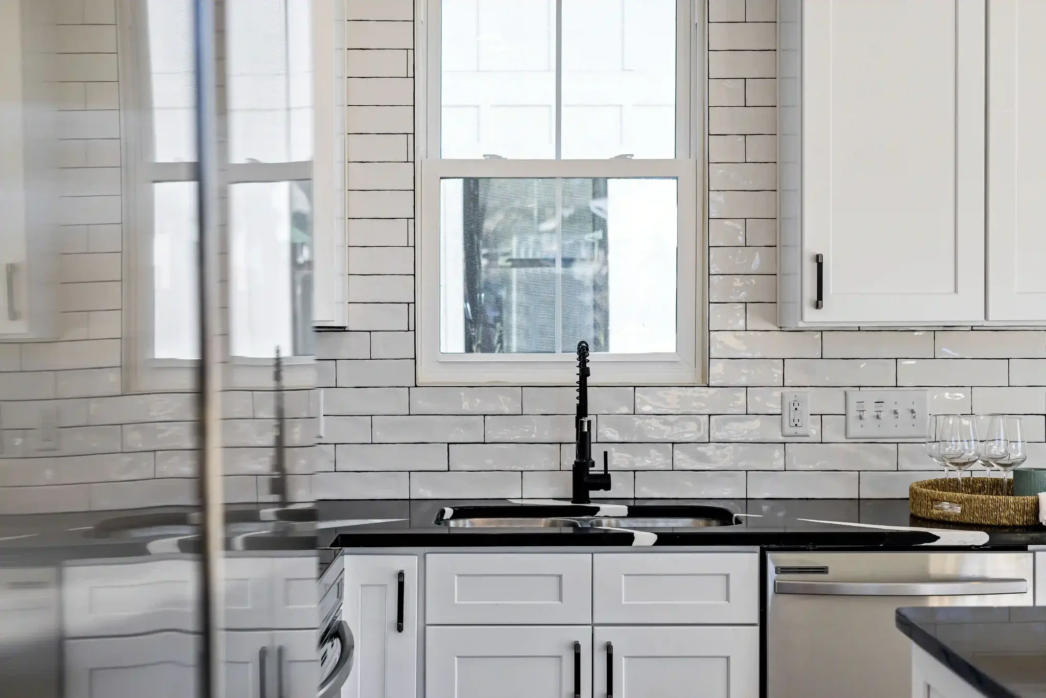 White shaker kitchen with classic white subway tile backsplash and matte black farmhouse faucet